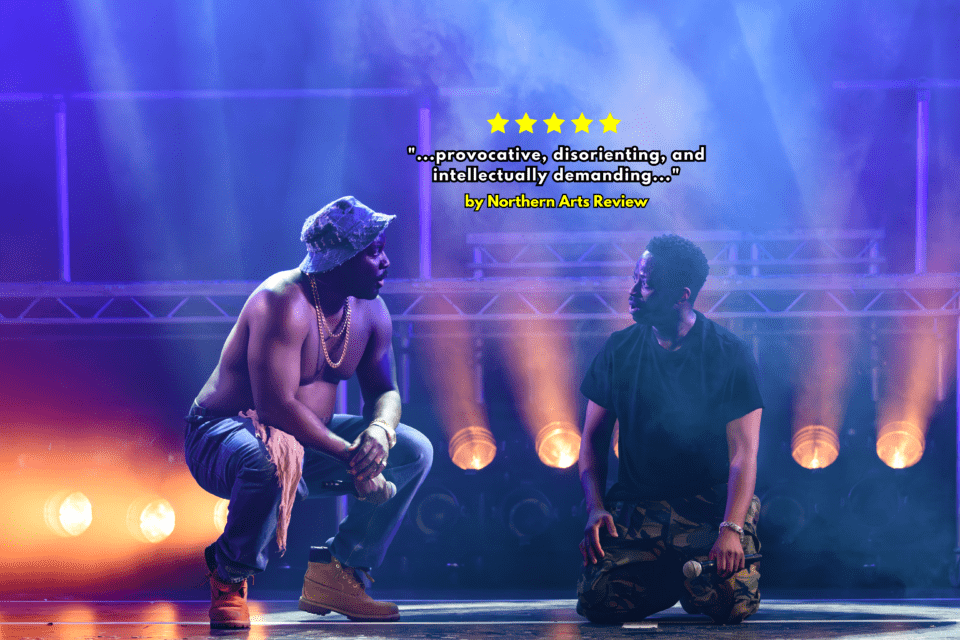 Two men crouch on the stafe in DJ lights for the stage production of Tambo & Bones