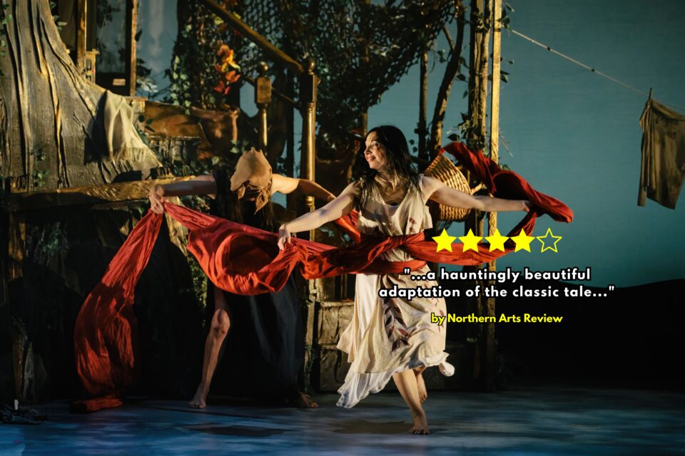 A ballet dancer holds a red length of fabric