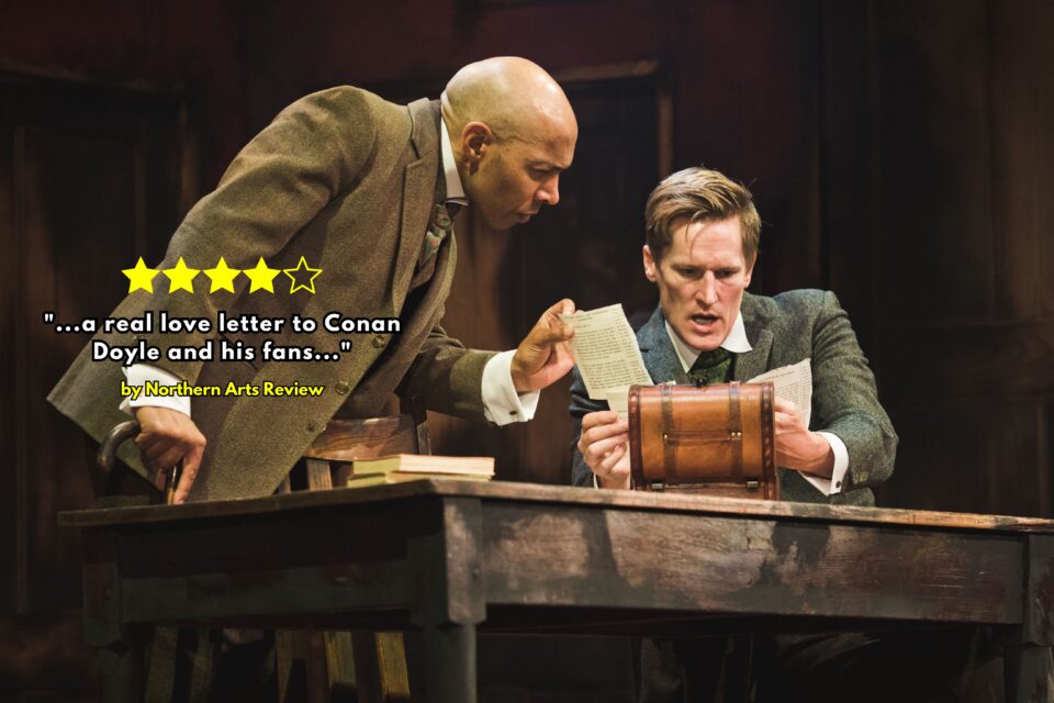 Watson leans over the desk, looking at paperwork with Sherlock at the Cast theatre performance